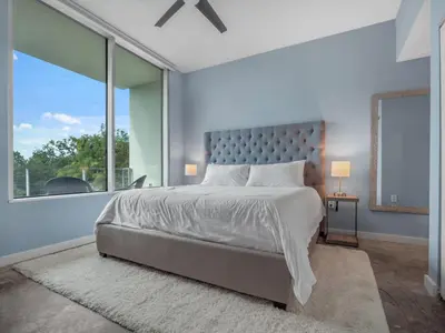 a bedroom with a large bed and a large window at Luxurious 2 Beds 2 Baths Downtown Apartment in Orlando