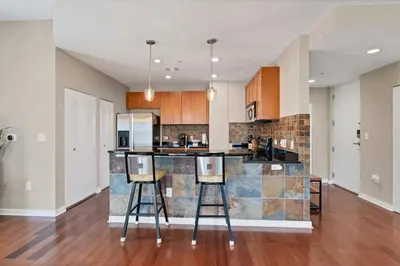 a kitchen with a counter and two bar stools at Beautiful Downtown Condo 1 Bed 1 Bath in Orlando
