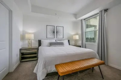 a white bedroom with a large bed and a window at Apartamento 3BR/2BA – A 10 Min dos Parques Disney! in Kissimmee