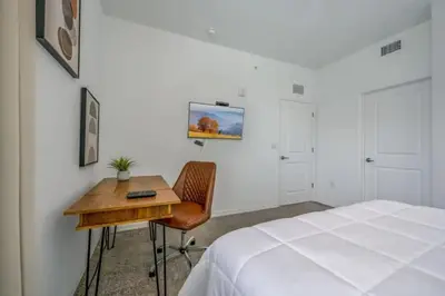 a bedroom with a bed and a desk next to a bed at Apartamento 3BR/2BA – A 10 Min dos Parques Disney! in Kissimmee