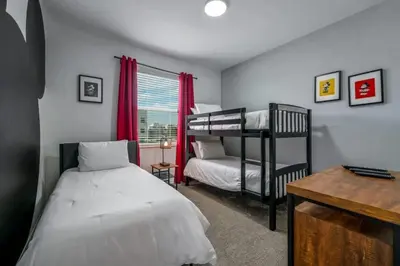 a bedroom with two bunk beds and a desk at Apartamento 3BR/2BA – A 10 Min dos Parques Disney! in Kissimmee