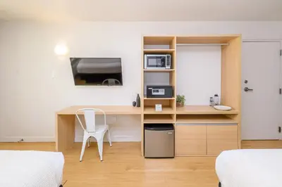 a bedroom with a desk with a computer and a tv at Modern- 2 Queen bed suite with pool near Disney World in Kissimmee