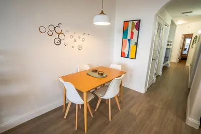 a dining room with a wooden table and white chairs at Orlando Blue Heron 1 Mile From Disney 11th floor in Orlando