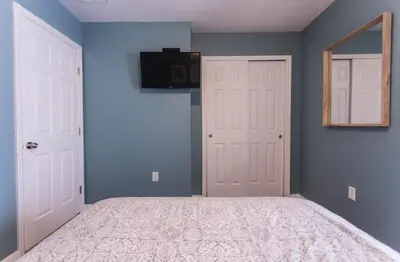 a bedroom with a bed with blue walls and a mirror at Magic Starts Here! Minutes to Disney Land in Orlando