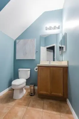 a blue bathroom with a toilet and a sink at Magic Starts Here! Minutes to Disney Land in Orlando