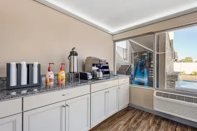 a kitchen with white cabinets and a large window at Red Roof Inn Kissimmee, FL in Kissimmee