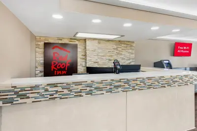 an office with a red roof trump sign on a wall at Red Roof Inn Kissimmee, FL in Kissimmee