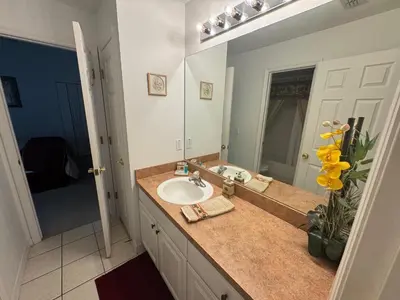 a bathroom with a sink and a large mirror at Sunset Villa – Your Gateway to a Magical Florida Vacation! in Kissimmee