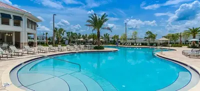 a swimming pool at a resort with chairs and palm trees at FLASH SALE Pvt Pool and Spa Home at Storey Lake in Kissimmee