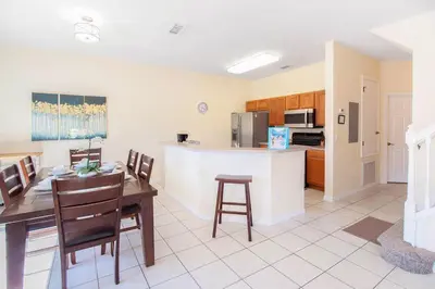 a kitchen and dining room with a table and chairs at Flash 20 Off Amazing Pvt Pool Townhome in Kissimmee