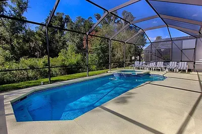 a swimming pool with a canopy and chairs in it at Charming 4-Bedroom Villa with Pool & Spa, Only 15 Minutes from Disney! in Kissimmee