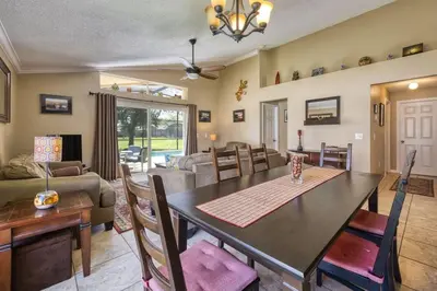 a dining room and living room with a table and chairs at Flash 20 Off Private Pool Home at Lake Berkley Resort in Kissimmee