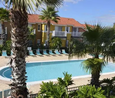 a swimming pool in front of a resort with palm trees at Flash 20 Off Private Pool Home at Lake Berkley Resort in Kissimmee