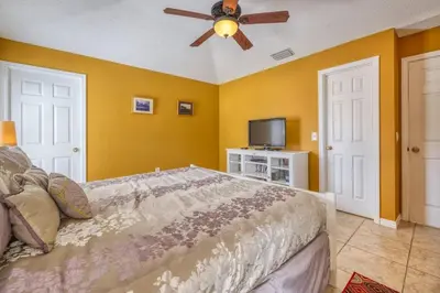 a bedroom with a bed and a ceiling fan at Flash 20 Off Private Pool Home at Lake Berkley Resort in Kissimmee