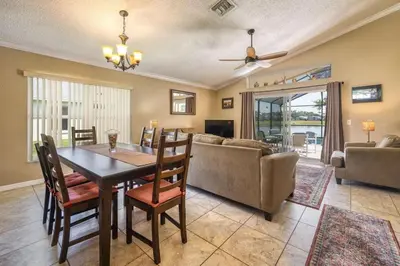 a dining room and living room with a table and chairs at Flash 20 Off Private Pool Home at Lake Berkley Resort in Kissimmee
