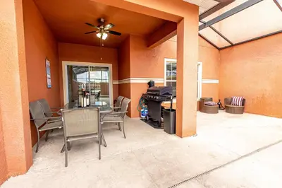 a patio with a table and chairs and a ceiling fan at Flash 20 Off Spetacular TownHome With Private Pool close to Disney 8919PP in Kissimmee