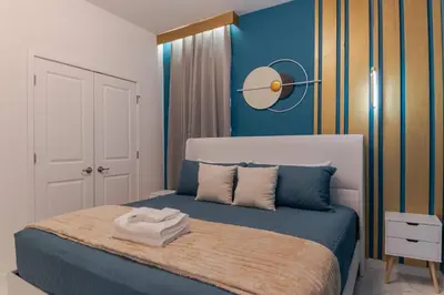 a bedroom with a bed with a blue wall at Sophisticated 9 bedroom close to Disney in Kissimmee