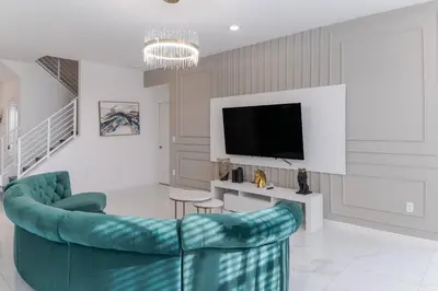 a living room with a couch and a tv at Sophisticated 9 bedroom close to Disney in Kissimmee