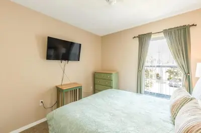 a bedroom with a bed and a flat screen tv at Flash 20 Off Townhome at Emerald Island Resort in Kissimmee