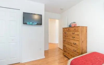 a bedroom with a dresser and a tv on a wall at Flash 20 Off Townhome at Emerald Island in Kissimmee