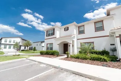 a large white house with a street in front of it at Flash 20 Sale Pvt Pool Townhome at Storey Lake in Kissimmee