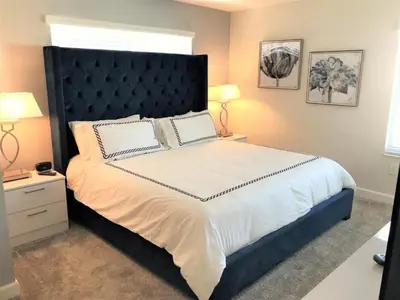 a bedroom with a large bed with a black headboard at Flash 20 Sale Pvt Pool Townhome at Storey Lake in Kissimmee