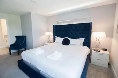 a bedroom with a large white bed with a blue headboard at Flash 20 Sale Pvt Pool Townhome at Storey Lake in Kissimmee