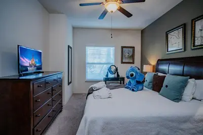 a bedroom with a bed with a tv and a dresser at Special Offer Cozy Townhome at West Lucaya in Kissimmee