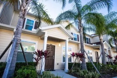 a house with palm trees in front of it at Special Offer Cozy Townhome at West Lucaya in Kissimmee