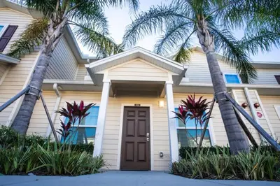 a house with palm trees in front of it at Special Offer Cozy Townhome at West Lucaya in Kissimmee