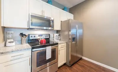 a kitchen with a stainless steel refrigerator and white cabinets at Special Offer Elegant Townhome at West Lucaya in Kissimmee