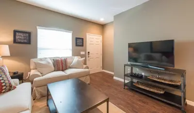 a living room with a couch and a flat screen tv at Special Offer Elegant Townhome at West Lucaya in Kissimmee