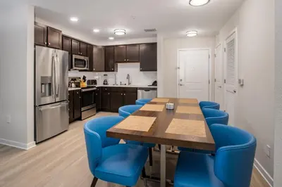 a kitchen with a wooden table and blue chairs at New Modern Vista Cay Reserve Condo - 6007 in Orlando