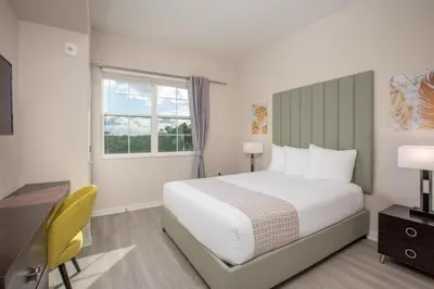 a bedroom with a bed and a desk and a window at New Modern Vista Cay Reserve Condo - 6007 in Orlando