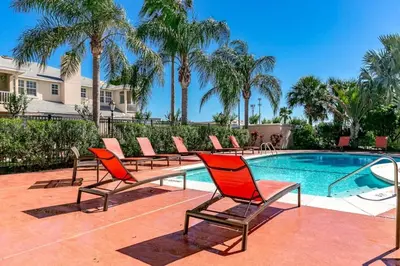 a group of chairs sitting next to a swimming pool at Special Offer Cozy Retreat at Compass Bay in Kissimmee