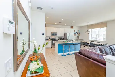 a living room and kitchen with a couch and a table at Special Offer Fantastic Townhome with Pvt Pool and Lake view near Disney in Kissimmee