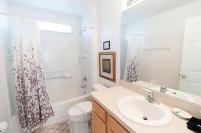 a white bathroom with a sink and a toilet at Special Offer Private Pool Home at Seasons Community in Kissimmee