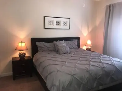 a bedroom with a large bed with two lamps at Special Offer Pvt Pool Townhome in Kissimmee