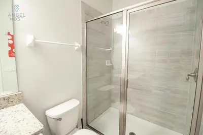 a bathroom with a toilet and a glass shower at Special Offer Pvt Pool and Spa Home at Encore in Orlando