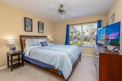 a bedroom with a bed and a flat screen tv at Special Offer Stunning TownHome With Private Pool close to Disney 8960PP in Kissimmee