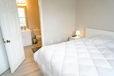 a bedroom with a large white bed and a bathroom at New Luxury Disney Townhome at Windsor Hills Resort, 3BED 3BATH, Private Pool Parking WiFi Included in Orlando
