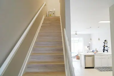 a staircase in a home with white walls and wooden floors at New Luxury Disney Townhome at Windsor Hills Resort, 3BED 3BATH, Private Pool Parking WiFi Included in Orlando