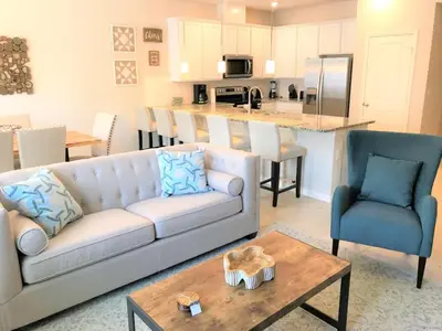 a living room with a couch and a table and a kitchen at Special Offer Townhome at Compass Bay in Kissimmee