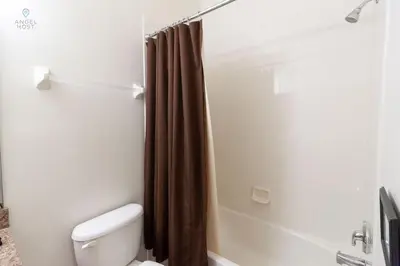 a bathroom with a toilet and a shower with a shower curtain at Special Offer Townhome at Oakwater Resort in Orlando