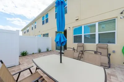 a table with a blue umbrella on a patio at TVPM5164ADCB in Kissimmee