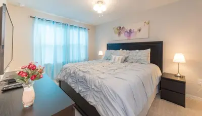 a bedroom with a bed and a desk with a vase of flowers at TVPM5164ADCB in Kissimmee
