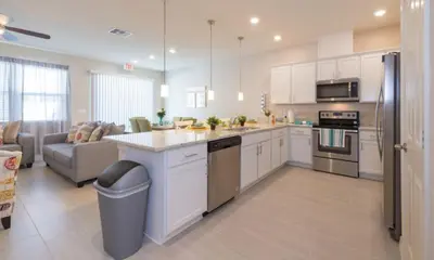 a large kitchen with white cabinets and a couch at TVPM5164ADCB in Kissimmee
