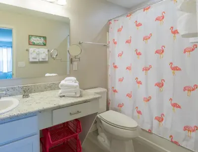 a bathroom with a toilet and a shower curtain with pink flamingos at TVPM5164ADCB in Kissimmee