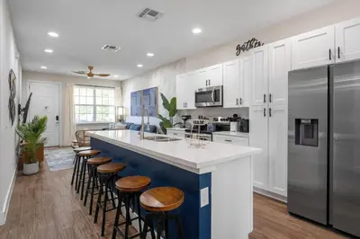 a kitchen with a large island with stools and a counter at New Listing - Modern decoration 4 BR Townhouse in Kissimmee