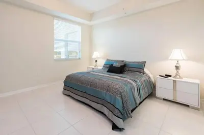 a white bedroom with a bed and a window at Aconchegante 3Q no Storey Lake – 10 min da Disney! in Kissimmee